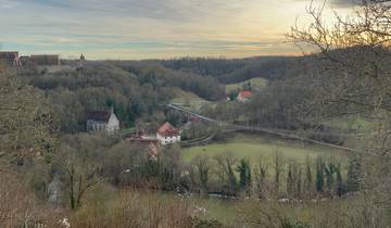 Expansive view of fields and houses with a bridge at sunset.
