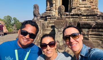 Tourists posing in front of ancient stone statues.