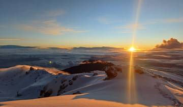 Dramatic sunrise view from a snowy mountain peak.