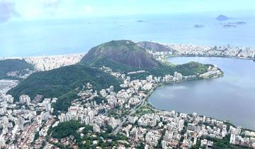 Panoramic aerial view of a city with a lagoon and hills.