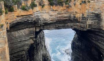 Natural arch rock formation over the sea.