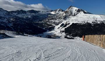 A snowy mountain landscape with clear skies and rugged peaks.