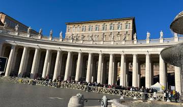 Impressive architectural structure with columns and sculptures under a blue sky.