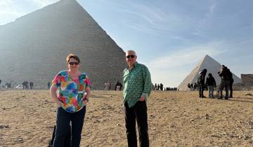 Two people posing in front of the Pyramids.