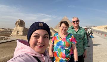 Three people posing near the Sphinx and Pyramid in Giza.