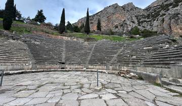 Ancient amphitheater with mountains in the background.