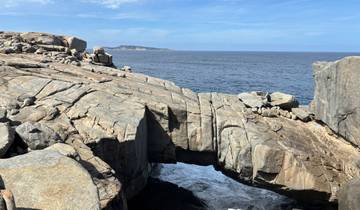 Rocky coastline with natural arch formation jutting into the sea.