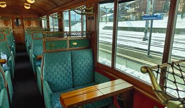 Interior of a vintage train looking out to snow-covered platform.