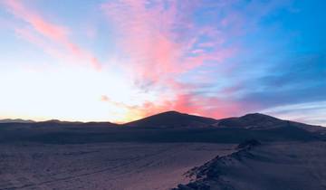 Beautiful sunset over desert dunes with colorful skies.