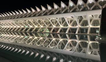 Illuminated modern architectural structure with symmetrical reflections.