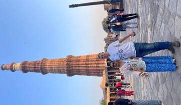 Couple posing in front of the iconic Qutub Minar.
