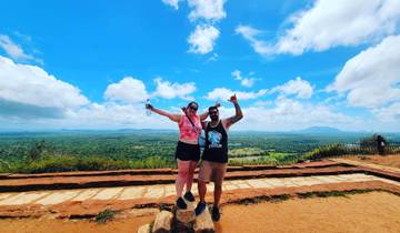 Two people celebrating on a scenic overlook with vast landscapes.