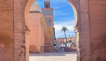 View through a decorative archway towards a mosque with scaffolding.