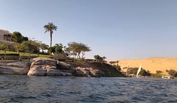 Scenic river view with rocks, trees, and a distant boat.