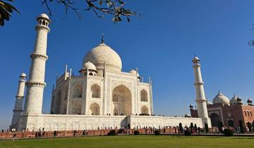 The Taj Mahal on a clear day with visitors in the foreground.