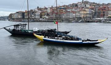 Traditional boats on a river with cityscape in the background.