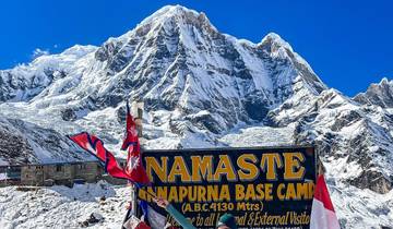 Majestic view of the Annapurna Base Camp with a sign and snow-capped mountains.