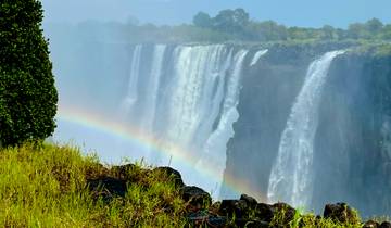 A spectacular view of a waterfall with a rainbow in front.