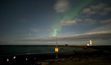 Northern lights over a coastal area at night.