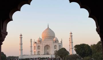 Taj Mahal framed by an archway during sunset.
