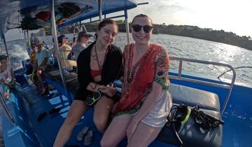 Two women sitting on a boat, smiling.