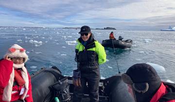People on inflatable boats in icy water, Antarctica.