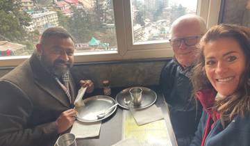 Three people dining indoors with a window view.