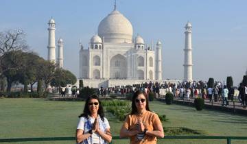 Two people posing in front of the Taj Mahal, hands together in front.