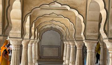 Ornate arches in a historical building with people exploring.
