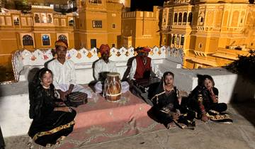 Group of traditional Indian musicians sitting with instruments.