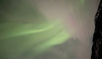 Aurora lights in the night sky with stars visible.