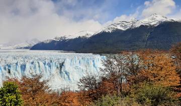 A glacier with snowy mountains and autumn foliage.