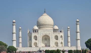 The Taj Mahal with a clear blue sky and tourists below.