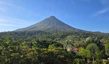 View of Arenal Volcano with a lush green forest in the foreground.