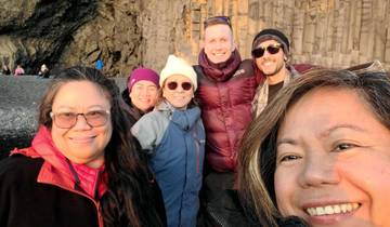 Group selfie at a rocky beach location.
