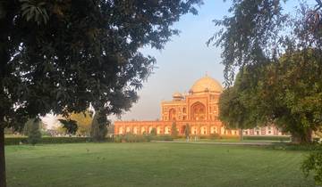 Mausoleum set in a lush garden with trees framing the view.