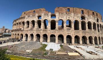 Colosseum in Rome, partially lit, with people around.