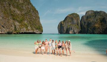 Group of women on a tropical beach with cliffs.