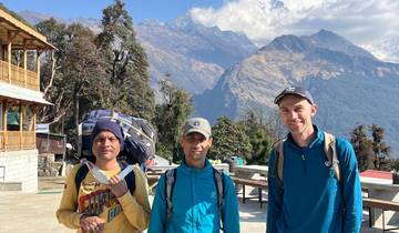 Three hikers with mountains in the background.