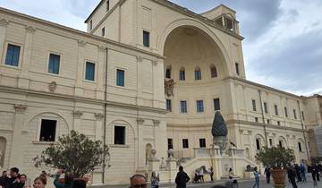 Large historical building with people exploring the courtyard.
