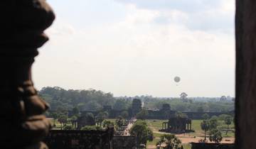 View of Angkor Wat with a hot air balloon in the sky.