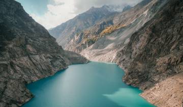 Aerial view of a turquoise lake surrounded by mountains.