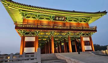 Illuminated traditional Korean gate at dusk.