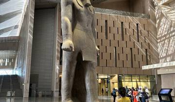 Large statue inside a modern museum with a group of visitors.