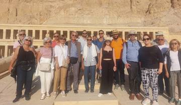 Group of tourists posing in front of an ancient temple.