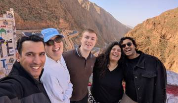 Group of friends smiling with a scenic mountainous backdrop.