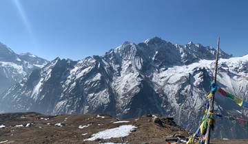 Snow-capped mountain range with prayer flags.