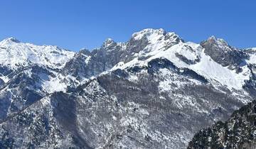 Snow-covered mountain peaks under a clear blue sky.