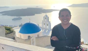 Person with scenic view of Santorini and sea.