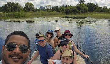 Group of people on a boat amidst a lush landscape.